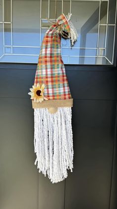 a scarf hanging on the side of a building with sunflowers attached to it