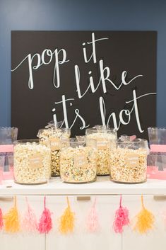 the popcorn bar is set up with pink and yellow pom poms