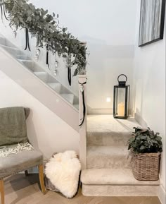 the stairs are decorated with greenery and hanging lanterns for an elegant touch to this home