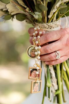 a person holding a bouquet with flowers and pictures hanging from it's side,