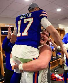 two football players hugging each other in the locker room