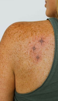 the back of a woman's shoulder with small stars on it