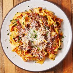 a white plate topped with pasta covered in sauce and parmesan sprinkles