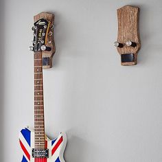 an electric guitar hanging on the wall next to a pair of wooden pegs with a british flag painted on it