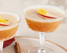 two glasses filled with drinks sitting on top of a table