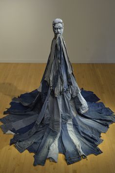 a sculpture made out of old jeans on a wooden floor