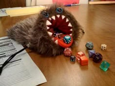 a stuffed animal that is sitting on the floor with dice in it's mouth