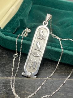 Vintage Silver Egyptian Cartouche pendant. Unisex pendant. Egyptian good luck symbol. Hieroglyphs silver necklace. Circa 70 - 80s. Mark: Egyptian stamp  Condition: pendant in perfect condition. Materials: 800 silver. Measure: 1.8" x 0.5"/ 4.0 x 1.2 cm.  Postage: Gift wrap available, please specify when ordering. Delivery: your order will be sent by Royal Mail with tracking information in 1-2 working days. Thanks for visiting. Silver Hallmarked Necklace, Silver Hallmarked Necklace For Good Luck, Hieroglyphic Name Necklace, Symbolic Ankh Sterling Silver Necklaces, Vintage Silver Ankh Jewelry, Vintage Engraved Ankh Jewelry, Egyptian Cartouche Necklace, Good Luck Symbols, Silver Gifts