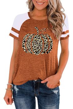 a woman wearing an orange and white shirt with leopard print pumpkin on the front,