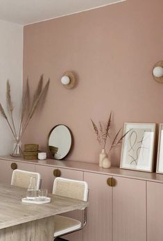 a dining room with pink walls and white chairs