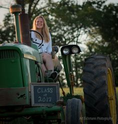 a woman sitting on top of a green tractor