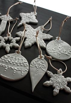 christmas ornaments are arranged on a table with string hanging from the top, and one ornament has snowflakes attached to it