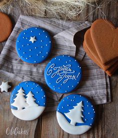 four decorated cookies sitting on top of a wooden table