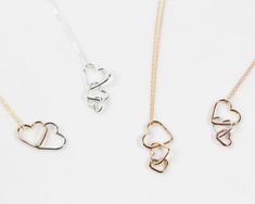 Celebrate enduring love with our Cascading Hearts Necklace, crafted by our treasured artisans. This necklace features one, two, or three connected hearts, symbolizing unbreakable bonds and cherished connections. Meticulously handcrafted from high-quality materials, each heart cascades gracefully downward, displaying heartfelt affection. Personalize the necklace by selecting the number of hearts, their size, and the type of fine metal for each one. The delicate 1.1mm chain, available in various p Handmade Double Heart Necklaces For Anniversary, Wedding Jewelry With Adjustable Double Heart Chain, Adjustable Double Heart Necklace For Anniversary, Adjustable Double Heart Jewelry For Anniversary Gift, Double Heart Jewelry With Heart Beads For Anniversary, Wedding Double Heart Charm Necklace With Heart Beads, Handmade Double Heart Jewelry For Anniversary, Adjustable Double Heart Wedding Necklace, Delicate Double Heart Necklace For Anniversary Gift