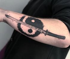 a man with a knife tattoo on his arm