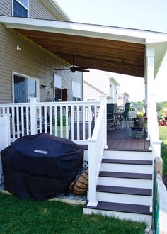 a covered porch with stairs leading up to the front door and back deck area,