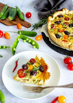 a slice of vegetable quiche on a plate with a fork next to the pie