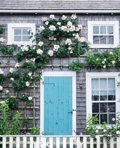 a house with flowers growing on the side of it