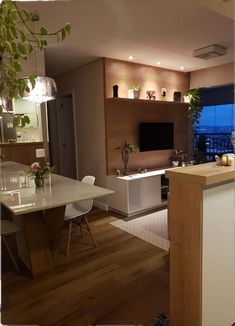 a kitchen and living room are shown in this image, with the tv on above the counter