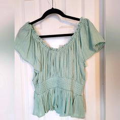 Elevate Your Style With This Beautiful Lane Tree Blouse, Perfect For Any Occasion. This Gorgeous Piece Features An Off-The-Shoulder Neckline, Flutter Sleeves, And Pleated Accents, Making It A Unique And Eye-Catching Addition To Your Wardrobe. The Mint Green Color Is Fresh And Versatile, While The Size Large Ensures A Comfortable And Flattering Fit. Ideal For Pairing With Jeans Or Dressing Up With A Skirt, This Blouse Is Sure To Become A Go-To Favorite. (Jeans In Pic Sold Separately) Green Smocked Top With Short Sleeves For Summer, Flowy Short Sleeve Peasant Top For Day Out, Flowy Green Peasant Top For Summer, Casual Flowy Peplum Top, Green Flowy Casual Blouse, Cotton Short Sleeve Flowy Tops, Flowy Cotton Short Sleeve Tops, Flowy Cotton Tops With Short Sleeves, Flowy Green Summer Top