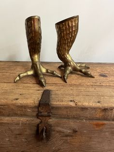 two metal hands are sitting on top of a wooden box