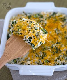 a casserole dish with spinach and cheese being scooped from the casserole