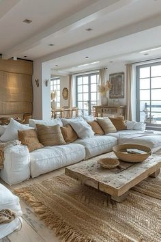 a living room filled with white furniture and lots of pillows on top of it's couches