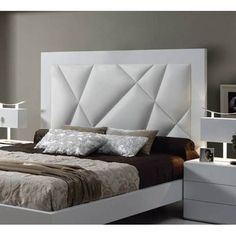 a white bed sitting next to a night stand with two nightstands on each side