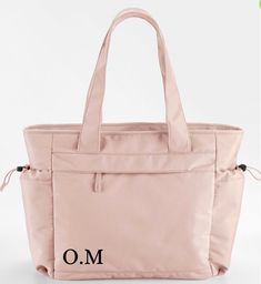 The Movement collection features a line-up of relaxed silhouettes, all designed for casual accessorising. Lightweight fabric and contemporary colours make every piece easy to use and effortless to style. This oversized tote boasts multifunctional pockets, including a padded laptop compartment, making it a true everyday essential. Toggle fastenings are inspired by premium outdoorsy brands, adding a touch of laid-back luxury. Made from 100% recycled polyester, the collection is another active step Trendy Travel Bag For Daily Use With Pockets, Trendy Travel Bag With Pockets For On-the-go, Trendy Travel Tote Bag With Pockets, Nylon Diaper Bag With Pockets For Daily Use, Practical Pink Bag With Pockets, Modern Bags With Pockets For On-the-go, Practical Pink Bags With Pockets, On-the-go Shoulder Bag With Functional Pockets And Double Handle, Pink Shoulder Bag With Pockets For On-the-go