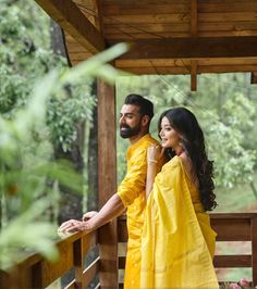 a man and woman dressed in yellow standing on a porch