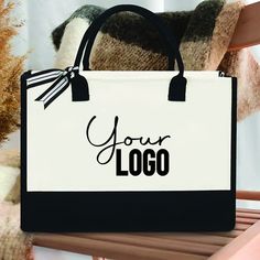 Elevate your everyday style with our Personalized Custom Logo, Text and Name Tote Bag, a versatile accessory that seamlessly blends fashion and functionality. This 11.81-inch tall, 17-inch long, and 9-inch wide bag is designed to add a touch of sophistication to your daily outings. What sets our Canvas Tote Bag apart is its unique design. The striking black base adds a sharp, contemporary edge to the bag, making it a standout piece in any ensemble. But what truly makes it extraordinary is the opportunity for personalization.  Not only is this tote bag a fashion statement, but it's also eco-friendly and perfect for those who value sustainability. Crafted to be reusable and sturdy, it's a practical choice for women of all ages in their daily lives.  Whether you're headed to the office, a wee Reusable Rectangular Bag For On-the-go, White Rectangular Bag With Laptop Sleeve, Black Reusable Shopping Bag, Eco-friendly White Canvas Bag For On-the-go, White Tote Laptop Bag For Daily Use, White Rectangular Laptop Bag For Daily Use, Reusable Black Shoulder Bag For Shopping, Reusable Black Bag For Everyday Use, Reusable Canvas Rectangular Bags