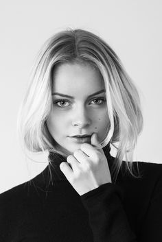 black and white photograph of a woman with blonde hair wearing a turtle neck sweater looking at the camera