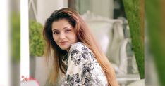 a woman with long hair posing for the camera