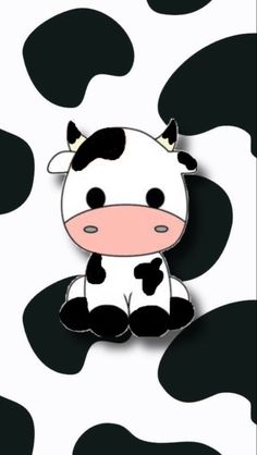 a cow sitting on top of a black and white pattern