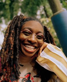 a smiling woman with glasses and dreadlocks