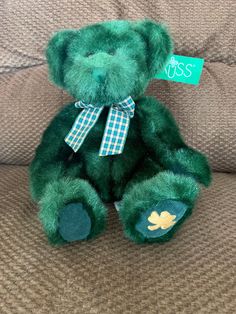 a green teddy bear sitting on top of a couch