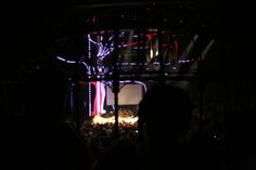 people are standing in front of a stage at night