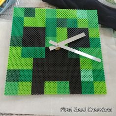 a green and black clock made out of lego blocks