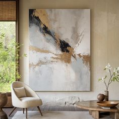 a living room with a painting on the wall next to a chair and coffee table