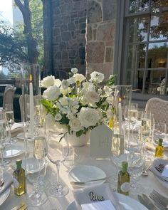 the table is set with white flowers and wine glasses