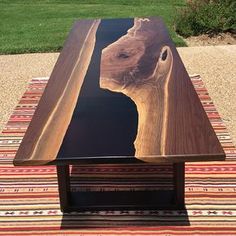 a coffee table made out of wood with a horse head on the top and bottom