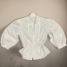 White gorgeous blouse with ruffle details on chest.  Very good condition.  It has a chic  style. Fits a modern S/M. Measurements Shoulders 36 CM  Bust 88 cm Sleeve length 45 cm  Length 53 cm Waist 80 cm  Everything is measured flat. SIZE on label 38 very good condition Pirate White Shirt, Classic Lantern Sleeve Tops For Daywear, Elegant Cotton Blouse With Gathered Sleeves, Spring Formal Shirt With Ruffled Collar, Formal Shirt With Ruffled Collar For Spring, Classic Tops With Bishop Sleeves For Daywear, Fitted Ruffle Blouse With Bishop Sleeves, Classic Bishop Sleeve Tops For Daywear, Elegant Cotton Puff Sleeve Top