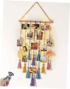 a wall hanging with pictures and tassels attached to it, next to a remote control