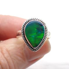 Aurora Opal is a man made stone consisting of Silica and Polymer rather than hydrated silica (natural opal). It comes in a variety of beautiful colors and almost glows with radiating color like the northern lights. Dimensions Size 7 | .7" long | .5" wide Spiritual Green Opal Ring Gift, Spiritual Green Opal Ring For Gift, Unique Green Opal Ring, Green Opal Ring Spiritual Style, Green Opal Spiritual Ring, Green Opal Ring Gift, Green Opal Ring As A Gift, Green Opal Cabochon Ring, Natural Opal