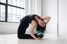 a woman in black shirt and leggings on the floor with her hands behind her head