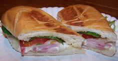 a cut in half sandwich sitting on top of a paper plate