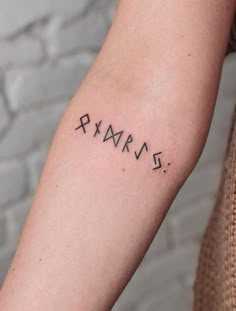 a woman's arm with roman numerals tattooed on the left side of her arm