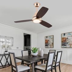 a dining room table and chairs with a ceiling fan in the middle of the room