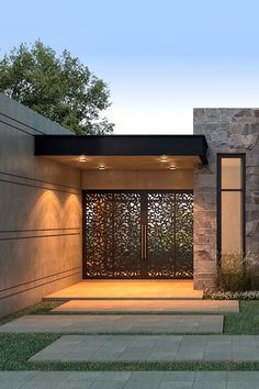 the entrance to a modern home with stone walls