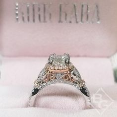 an engagement ring with two tone gold and white diamonds on it in a pink box